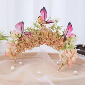 Detail view of gold baroque tiara with pink butterflies, silk flowers and pearls for hair accessory.