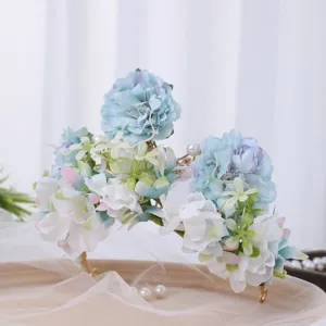 Detailed close-up of blue and white floral crown headband with pearls for photography.
