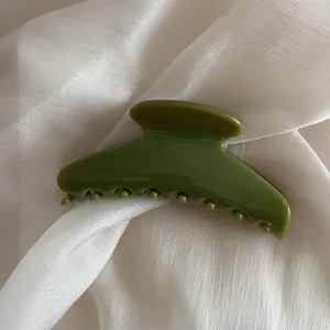 Close-up detail shot of a green hair claw clip, elegant jelly finish for daily styling.