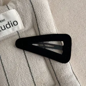 Black velvet snap hair clip detail close-up, simple and versatile styling accessory.