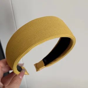 Detail de bandeau elargi cotele jaune, tissu texture en tricot doux, accessoire de cheveux.