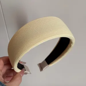 Gros plan détaillé d'un serre-tête large en tricot côtelé jaune clair, accessoire doux.