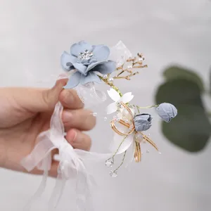 Elegante blauwe trouwpols-corsage versierd met parels, kristallen en delicate witte linten.