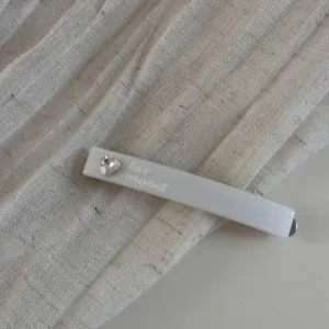 Vue détaillée de la pince à cheveux latérale en strass blanc, élégante barrette cœur scintillant.