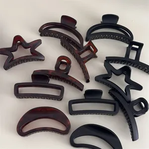 Ensemble de pinces à cheveux noires et brunes élégantes avec des formes géométriques et d'étoiles.