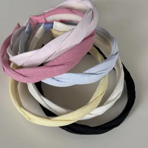 Gedetailleerd overzicht van gekruiste stoffen haarbanden in diverse pastel- en klassieke kleuren.