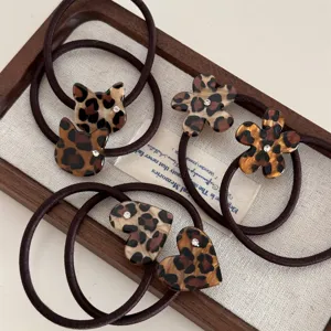 Detailed view of leopard print hair ties with cute cat flower heart shapes and rhinestone accents.