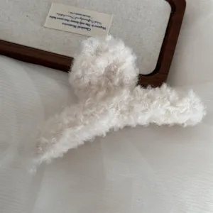 Cozy fluffy plush hair claw clip in creamy white, large size winter hair accessory detail.
