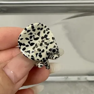 Gros plan détaillé d'une mini pince à cheveux en acétate avec motif dalmatien noir et blanc.