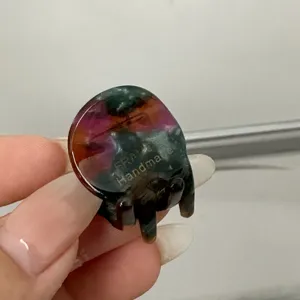Détail d'une mini pince à cheveux en acétate, présentant un motif coloré et une texture exquise.