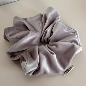 Λεπτομέρεια scrunchie μαλλιών από απαλό βελούδο, κομψό μονόχρωμο vintage αξεσουάρ.