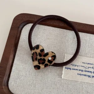 Detail shot of the cute leopard print heart hair tie with sparkling rhinestone accent.