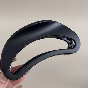 Pince à cheveux noire mate au design incurvé unique, accessoire de coiffure élégant pour femmes.
