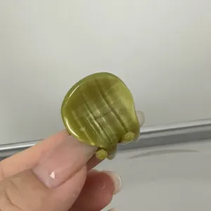 Gros plan montrant la texture exquise et la finition polie de la mini pince à cheveux verte.