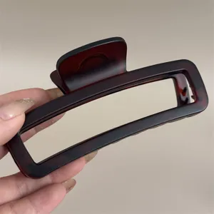 Détail de pince à cheveux rectangulaire marron foncé mate, accessoire élégant pour cheveux.