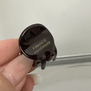 Détail de mini pince à cheveux en acétate, accessoire marron foncé pour frange et coiffure.
