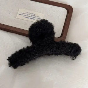 Large black plush hair claw clip for thick hair, cozy autumn winter hair accessory.