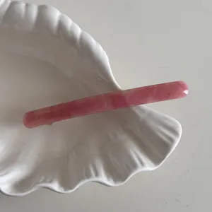 Fine barrette à cheveux en acétate rose avec motif marbré élégant et fermeture à ressort.
