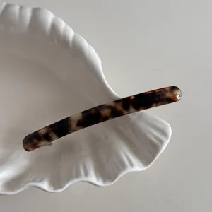 vue en detail de la pince a cheveux fine en acetate motif ecaille barrette elegante