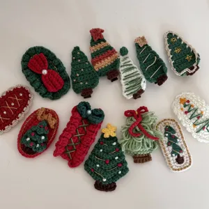 Detailed view of handmade crochet Christmas hair clips, cute knitted tree and bow designs.