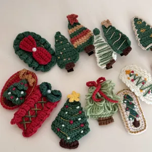 Close-up details of handmade crochet Christmas tree hair clips, cute knitted hair barrettes.