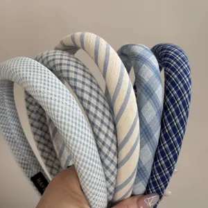 Detailed view of blue and white plaid and striped fabric headbands showing texture.