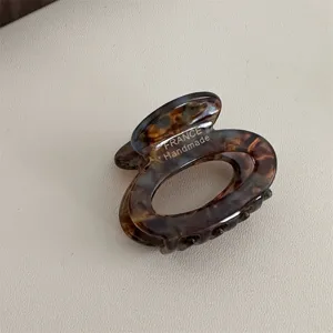 Detailed view of a vintage tortoiseshell acetate hair claw clip, small oval French hair accessory.