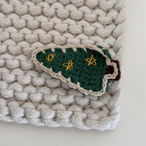 Handcrafted crochet Christmas tree hair clip detail view, cute knit side clip for sweet girls.