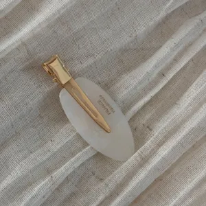 Minimalist oval hair clip with gold metal duckbill clip, elegant daily hair accessory detail.
