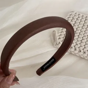 Close-up detail of the retro dark brown wide hair hoop showing soft leather texture and inner handmade label.