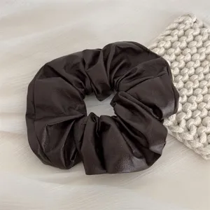 Dark brown faux leather scrunchie detail close-up showing soft texture and fine stitching.