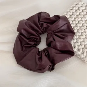 Dark maroon leather scrunchie detail view, elegant soft hair tie accessory for women.