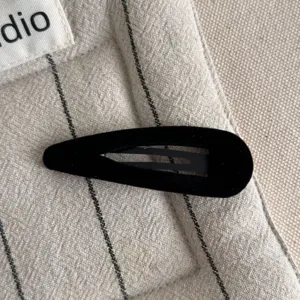 Close-up detail of a black velvet snap hair clip featuring soft texture and simple stylish design.