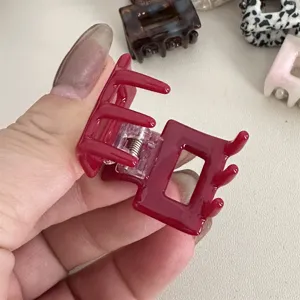Close-up detail of a minimalist solid red square mini hair claw clip, simple and chic accessory.