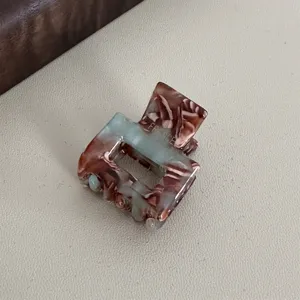 Detailed close-up view of a mini acetate hair claw clip with stylish tortoiseshell pattern.