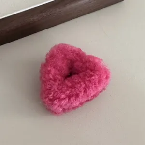 Fluffy pink heart hair claw clip detail close up, cute plush hair accessory for daily styling.
