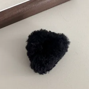 Black fluffy plush hair claw clip close-up, soft fuzzy texture for cute side bangs styling.