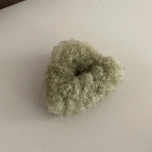 Detailed shot of the fluffy green plush hair accessory showing soft texture and cozy design.