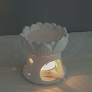 Primo piano dettagliato di un bruciatore di oli essenziali di loto in ceramica bianca.