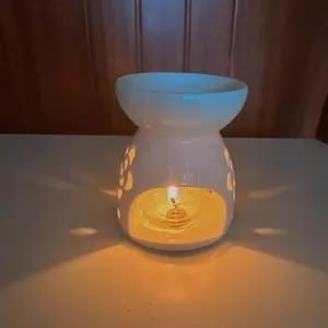 Bruciatore di oli essenziali in ceramica bianca con motivo floreale, accogliente diffusore di aroma.