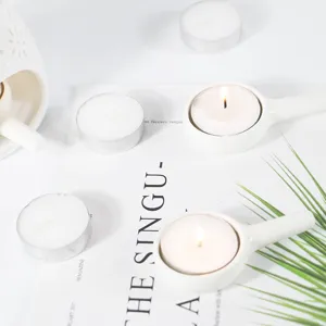 White ceramic tea light candle holder detail shot, minimalist porcelain aromatherapy accessory.