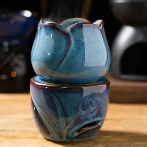 Detailed close-up of ceramic tulip oil burner, kiln-glazed blue aroma lamp for home decor.