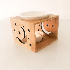 Wooden carved aroma oil burner detail shot showing star and moon patterns with tealight.