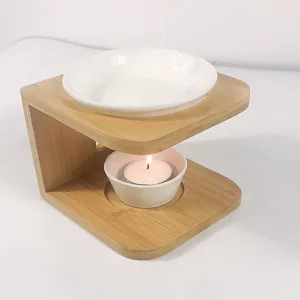 Wooden aromatherapy oil burner detail, white ceramic dish and tealight candle holder.