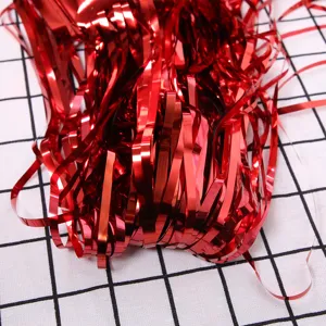 Red metallic tinsel fringe curtain for party decoration, shiny foil streamers backdrop.
