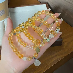 Vue rapprochée de bracelets de perles de cristal multicouches avec pierres jaunes et pendentif.