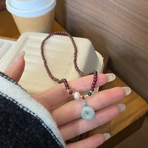 Detailansicht des chinesischen Retro-Granat-Armbands mit Jade-Friedensschnalle, elegant.