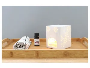 Vue de détail d'un brûleur d'huile essentielle en céramique blanche ajourée florale