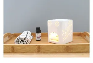 Vue de détail d'un élégant brûleur d'huile essentielle en céramique aux motifs floraux.