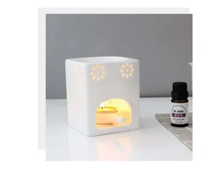 Brûleur d'huile essentielle en céramique blanche avec motif floral creux vue détaillée.